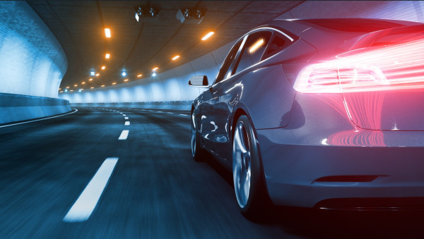 Car driving through a well-lit tunnel